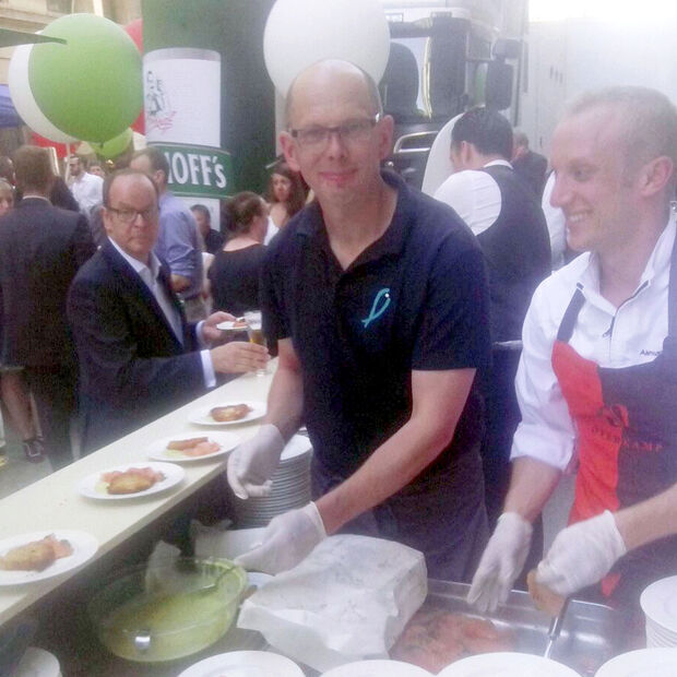 Kaum Zeit zum fotografieren, statt dessen eine Portion Fisch nach der anderen servieren: Frank Baumüller im Einsatz beim NRW-Sommerfest in Brüssel. FOTO: PRIVAT