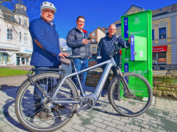 Stadtraum-Geschäftsführer Stefan Dittrich und sein Mitarbeiter Steffen Kampmeier sowie Bürgermeister Dr. Martin Michalzik (CDU) am heutigen Donnerstag bei der Inbetriebnahme der neuen E-Bike-Akku-Ladeboxen am Marktplatz in Wickede. FOTO: ANDREAS DUNKER