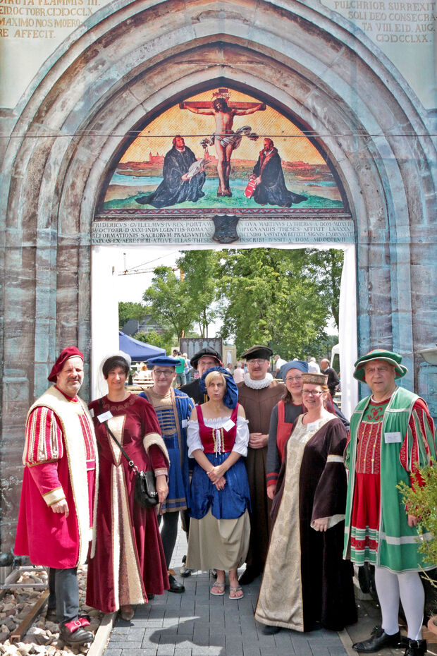 Durch die Nachbildung des Portals der Schlosskirche in Wittenberg schritten die Gäste des evangelischen Gemeindefestes in den Pfarrgarten hinter dem Martin-Luther-Haus in Wickede. Für ein Gruppenfoto stellte sich unter dem Torbogen auch die kostümierten Helfer der Gemeinde auf. FOTO: ANDREAS DUNKER