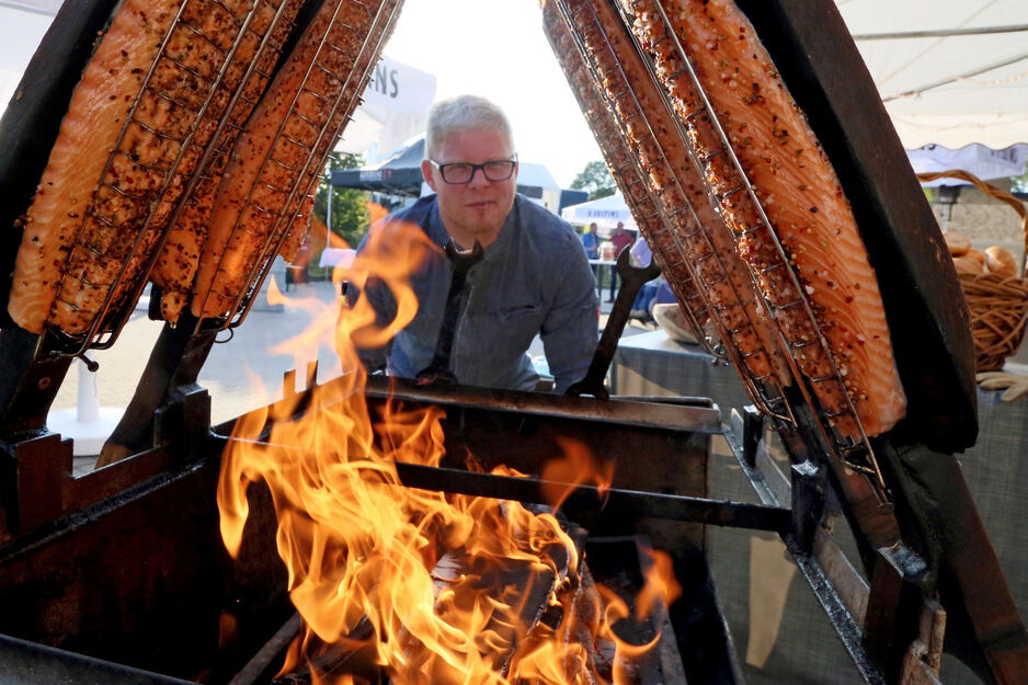 Koch John Sakoizie (Soest) vom Fischhof Baumüller bei der Zubereitung von "Graved Lachs" über einem offenen Buchholz-Feuer. Aufgenommen beim großen Dorffest 2017 des Fördervereins Dorf Wiehagen auf dem Hof Baumüller. ARCHIVFOTO: ANDREAS DUNKER ARCHIVFOTO: ANDREAS DUNKER