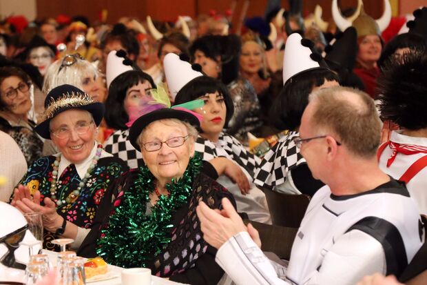 Mehr als 400 Gäste schunkelten und sangen im Bürgerhaus-Saal. Darunter auch Klementine Brinkmann (Mitte) und der evangelische Pfarrer Christian Klein (rechts). FOTO: CARINA WESTERWELLE