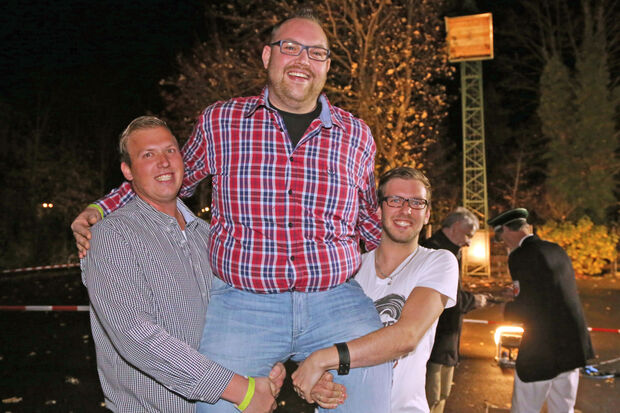 Christopher Horn (links) und Marco Engels (rechts) ließen den elften Wimberner Winterschützenkönig hochleben, nachdem die Reste des hölzernen „Schneemannes“ von Tobias Belz (Mitte) aus dem Kugelfang geschossen worden waren. FOTO: ANDREAS DUNKER