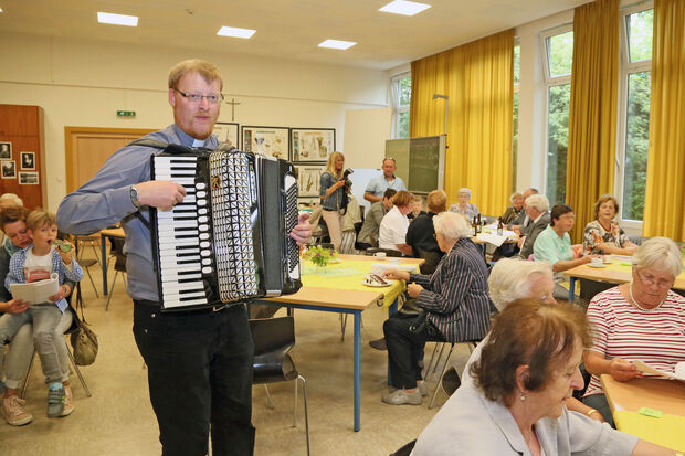 Kolping-Präses Vikar Alexander Plümpe spielte Volkslieder auf dem Akkordeon, die die Besucher des Kolping-Sommerfestes mitsingen konnten. FOTO: ANDREAS DUNKER