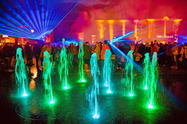 Laser-Show auf dem Werler Marktplatz mit illuminierten Wasserfontänen und bunt beleuchtetem Volksbank-Gebäude FOTO: ANDREAS DUNKER