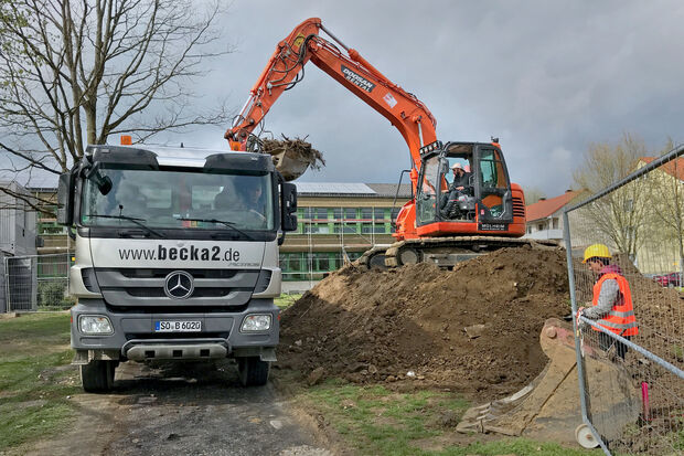 Während die Lehrer und Schüler in den Ferien sind, sind die Bauleute fleißig: Ein Zwölf-Tonnen-Kettenbagger schafft durch Erdarbeiten den notwendigen Raum für die Bodenplatte des Erweiterungsbaus der Sekundarschule. FOTO: ANDREAS DUNKER