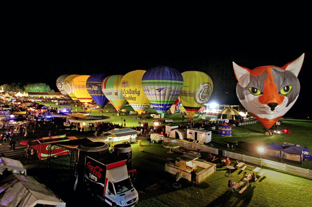 Night-Glow auf dem Gelände der Warsteiner Internationalen Montgolfiade. Im Hintergrund das Festzelt für die After-Ballooning-Party, in dem die Wickeder Coverband "Planless" am Samstag aufspielt. ARCHIVFOTO: ANDREAS DUNKER