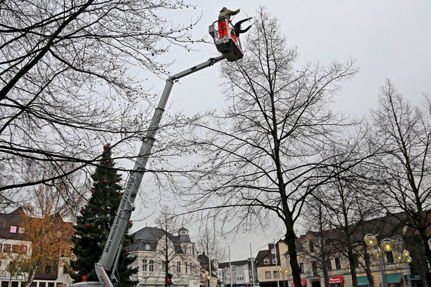 Mitarbeiter des Bauhofes Wickede montieren die Lichterketten in den Bäumen auf dem Wickeder Marktplatz FOTO: CARINA WESTERWELLE