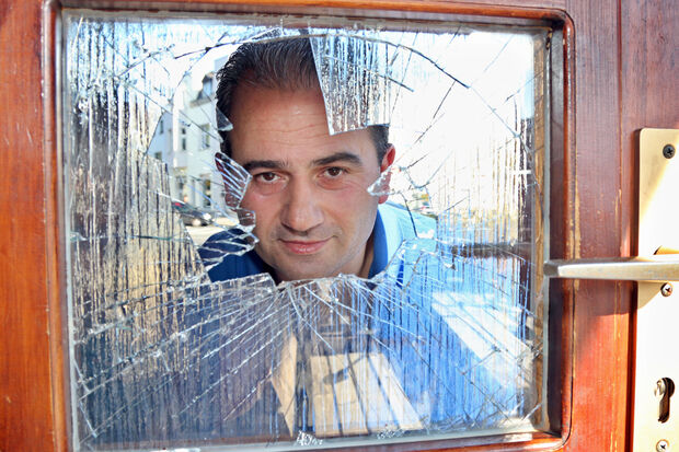 Versuchter Einbruch: Der Inhaber von "Chendis Wanted Döner Saloon“, Sendogan Güneser, blickt am heutigen Sonntag durch eine zerstörte Glasscheibe der Eingangstür. FOTO: ANDREAS DUNKER