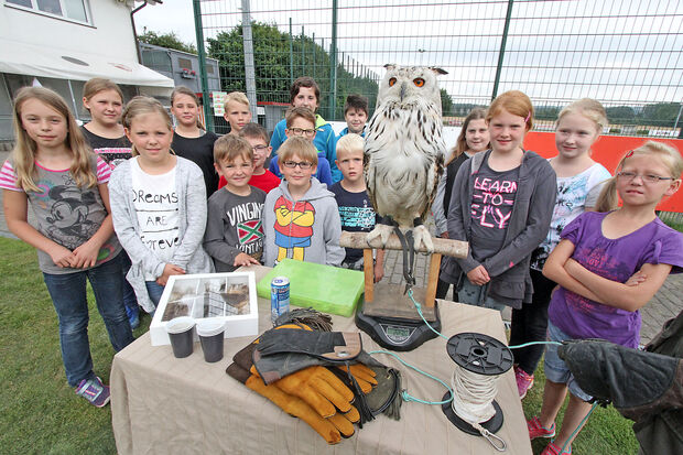 Gruppenbild mit Greifvogel: die Jungen und Mädchen rund um einen weißen Uhu FOTO