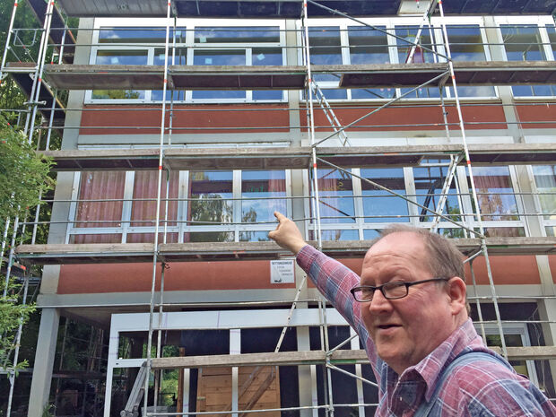 Hausmeister Michael Henke vor dem eingerüsteten Nordtrakt der Melanchthon-Grundschule. Er zeigt auf das erste neue Fensterelement mit Oberlicht. FOTO: ANDREAS DUNKER
