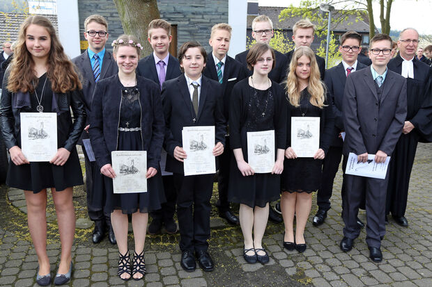 Konfirmation in der evangelischen Kirchengemeinde – Gruppenfoto vor der Christus-Kirche in Wickede. Vordere Reihe, von links: Eva Ersel, Lilli Knop, Björn Lüdorf, Klara Dämgen, Anna-Lena Lindner und Maik Sabelfeld. Hintere Reihe, von links: Julian Kessel, Joshua Krutzki, Dennis Stieben, Nico Wiedwald, Robin Schmoll und Michael Frühling sowie Pfarrer Dr. Christian Klein. FOTO: ANDREAS DUNKER