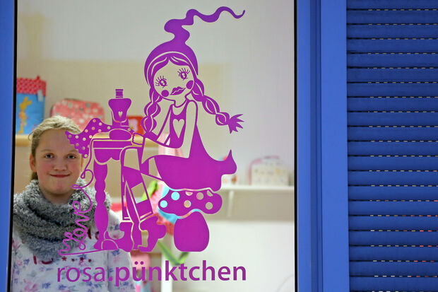 Anna Dieckmann (11) schaut durch die Schaufensterscheibe des neuen Ladenlokals ihrer Mutter. FOTO: ANDREAS DUNKER