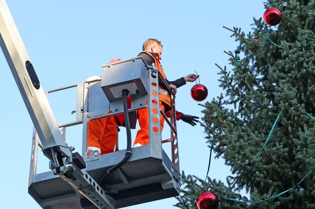 Keine Brandgefahr gibt es beim großen Weihnachtsbaum auf dem Marktplatz vor dem Wickeder Rathaus, den Mitarbeiter des Bauhofes mit roten Kugeln schmückten. ARCHIVFOTO: ANDREAS DUNKER